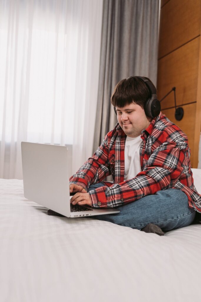 A Man in Plaid Long Sleeves Typing on His Laptop